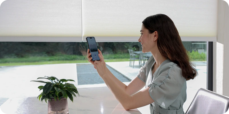 Using a smartphone app to control window blinds in a modern home setting.